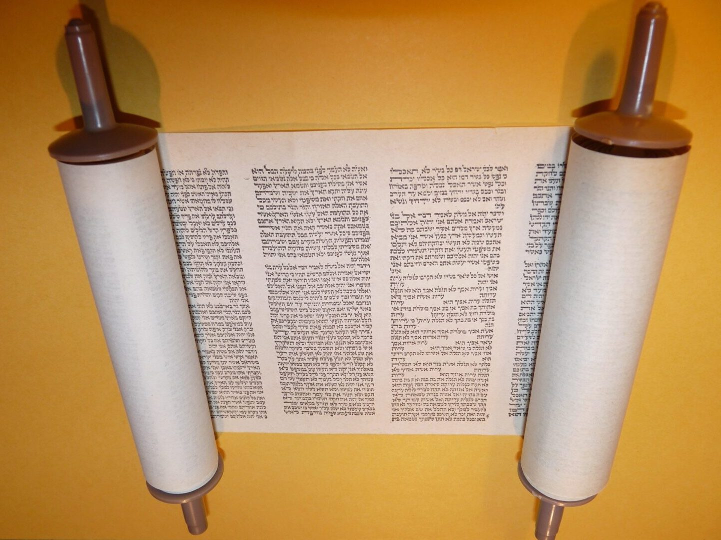 A torah scroll is shown with two rolls of paper.