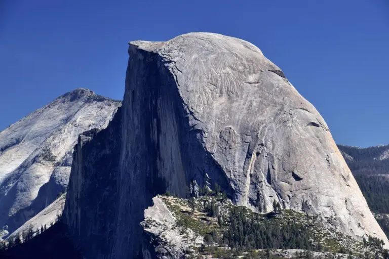 A large rock formation with trees in the foreground.