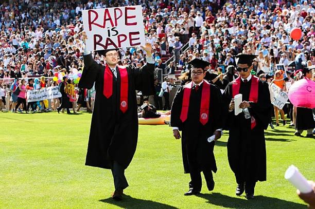 a student with a poster saying Rape is Rape